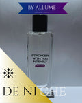 Clear rectangular perfume bottle with black cap, labeled 'Stronger With You Intensly', set against a light background with 'By Allume' and 'DE NICHE' graphic accents.